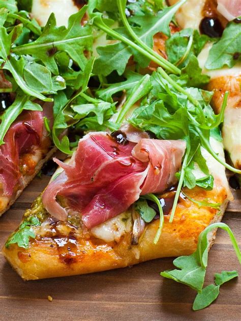 Prosciuttos pizza - Place back in the oven and cook for about 6 to 8 minutes. Then, remove the pizza from the oven again. Toss arugula over top, then diced shallots, drizzle with olive oil and sprinkle with salt. Gently place the prosciutto over top. You can fold it over it over or just toss randomly. Cut into slices with a pizza wheel.